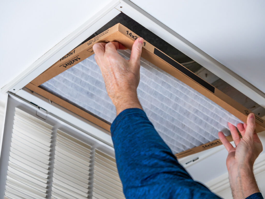 HVAC technician replacing a home air filter in Pacifica