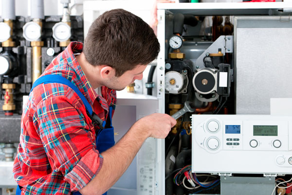 Heating technician repairing boiler controls in Pacifica
