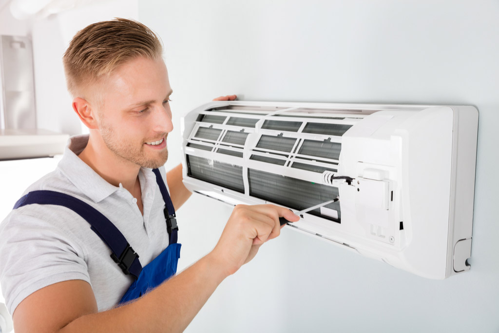 HVAC technician maintaining a ductless air conditioner in Pacifica