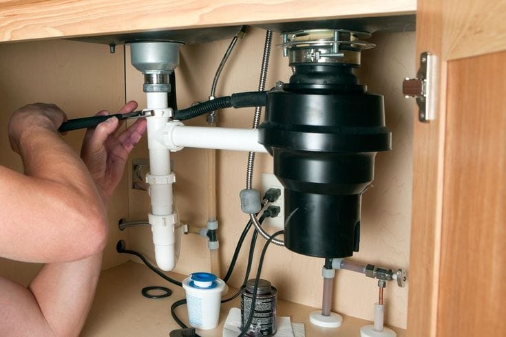 Plumber repairing a garbage disposal in Pacifica
