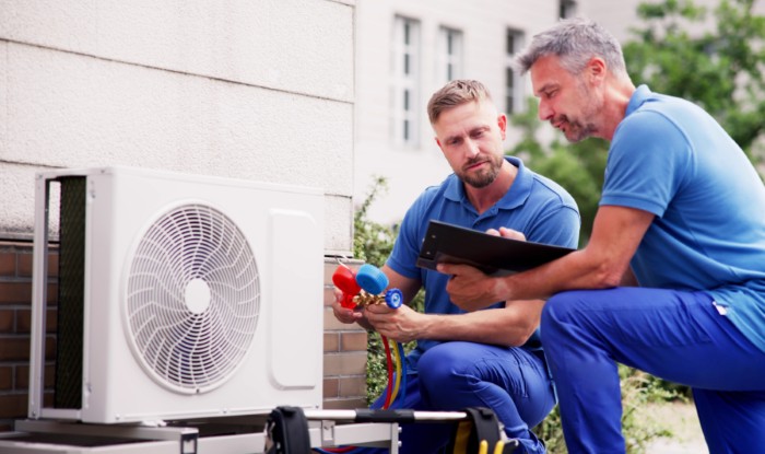 HVAC technicians installing an outdoor air conditioning unit in Pacifica